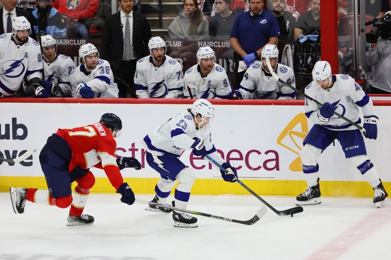 Apr 23, 2024; Sunrise, Florida, USA; Tampa Bay Lightning center Michael Eyssimont (23) moves the puck past Florida Panthers center Eetu Luostarinen (27) during the third period in game two of the first round of the 2024 Stanley Cup Playoffs at Amerant Bank Arena. Mandatory Credit: Sam Navarro-USA TODAY Sports