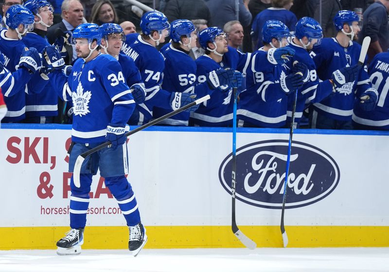 Jan 6, 2026; Toronto, Ontario, CAN; Toronto Maple Leafs center Auston Matthews (34) celebrates at the bench after scoring a goal against the Florida Panthers during the second period at Scotiabank Arena. Mandatory Credit: Nick Turchiaro-Imagn Images