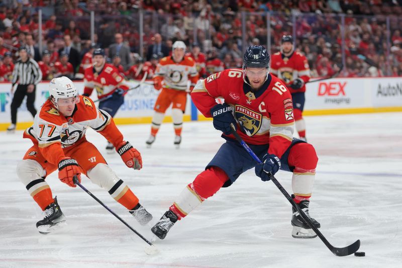 Jan 18, 2025; Sunrise, Florida, USA; Florida Panthers center Aleksander Barkov (16) moves the puck past Anaheim Ducks right wing Frank Vatrano (77) during the first period at Amerant Bank Arena. Mandatory Credit: Sam Navarro-Imagn Images