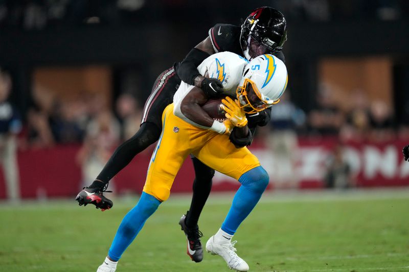 Los Angeles Chargers wide receiver Joshua Palmer (5) is tackled by Arizona Cardinals cornerback Max Melton after catching a pass during the second half of an NFL football game, Monday, Oct. 21, 2024, in Glendale Ariz. (AP Photo/Matt York)