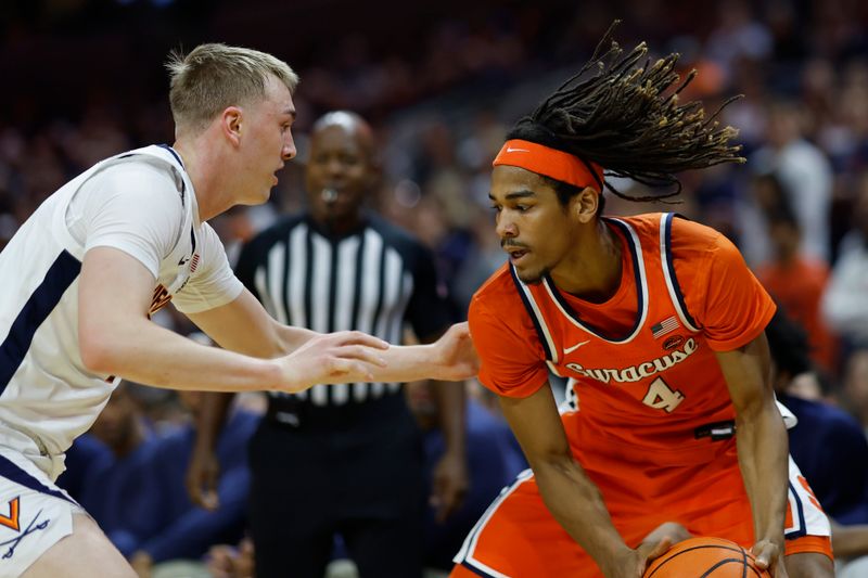 Dec 2, 2023; Charlottesville, Virginia, USA; Syracuse Orange forward Chris Bell (4) holds the ball as Virginia Cavaliers guard Andrew Rohde (4) defends during the first half at John Paul Jones Arena. Mandatory Credit: Geoff Burke-USA TODAY Sports