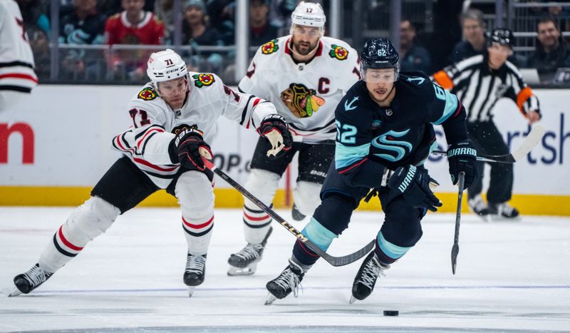 Nov 14, 2024; Seattle, Washington, USA;  Seattle Kraken defenseman Brandon Montour (62) skates against Chicago Blackhawks forward Taylor Hall (71) and forward Nick Foligno (17) during the first period at Climate Pledge Arena. Mandatory Credit: Stephen Brashear-Imagn Images