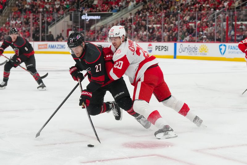 Dec 27, 2025; Raleigh, North Carolina, USA;  Carolina Hurricanes left wing Nikolaj Ehlers (27) is checked by Detroit Red Wings defenseman Albert Johansson (20) during the first period at Lenovo Center. Mandatory Credit: James Guillory-Imagn Images