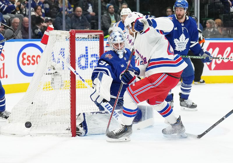 Dec 19, 2023; Toronto, Ontario, CAN; New York Rangers center Vincent Trocheck (16) battles for the puck in front of Toronto Maple Leafs goaltender Martin Jones (31) during the second period at Scotiabank Arena. Mandatory Credit: Nick Turchiaro-USA TODAY Sports