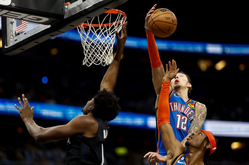 ORLANDO, FLORIDA - JANUARY 04: Lindy Waters III #12 of the Oklahoma City Thunder blocks a shot from Mo Bamba #11 of the Orlando Magic during the third quarter at Amway Center on January 04, 2023 in Orlando, Florida. NOTE TO USER: User expressly acknowledges and agrees that, by downloading and or using this photograph, User is consenting to the terms and conditions of the Getty Images License Agreement. (Photo by Douglas P. DeFelice/Getty Images)