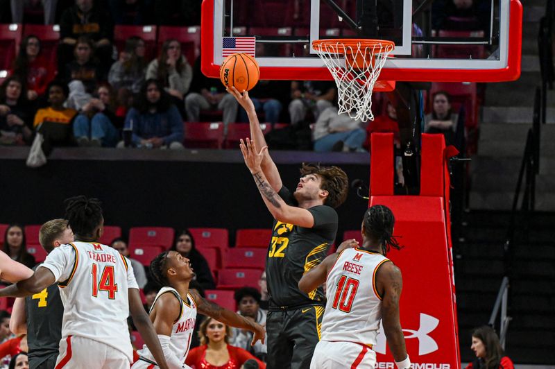 Feb 14, 2024; College Park, Maryland, USA;  Iowa Hawkeyes forward Owen Freeman (32) shoots as Maryland Terrapins forward Julian Reese (10) looks on during the second half at Xfinity Center. Mandatory Credit: Tommy Gilligan-USA TODAY Sports