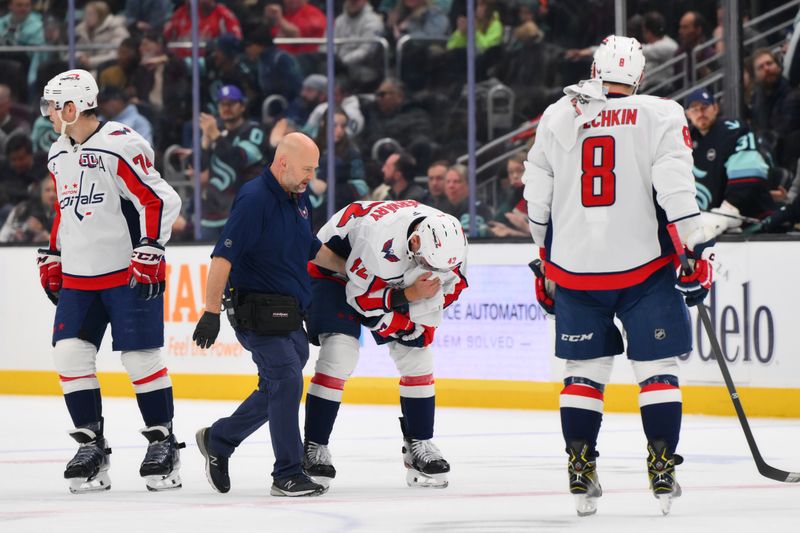 Jan 23, 2025; Seattle, Washington, USA; Washington Capitals defenseman Martin Fehervary (42) is helped off the ice after being hit in the face by the puck during the second period against the Seattle Kraken at Climate Pledge Arena. Mandatory Credit: Steven Bisig-Imagn Images