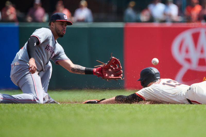 Apr 10, 2024; San Francisco, California, USA; San Francisco Giants outfielder Austin Slater (13) slides into second base against Washington Nationals second baseman Luis Garcia Jr. (2) during the second inning at Oracle Park. Mandatory Credit: Robert Edwards-USA TODAY Sports