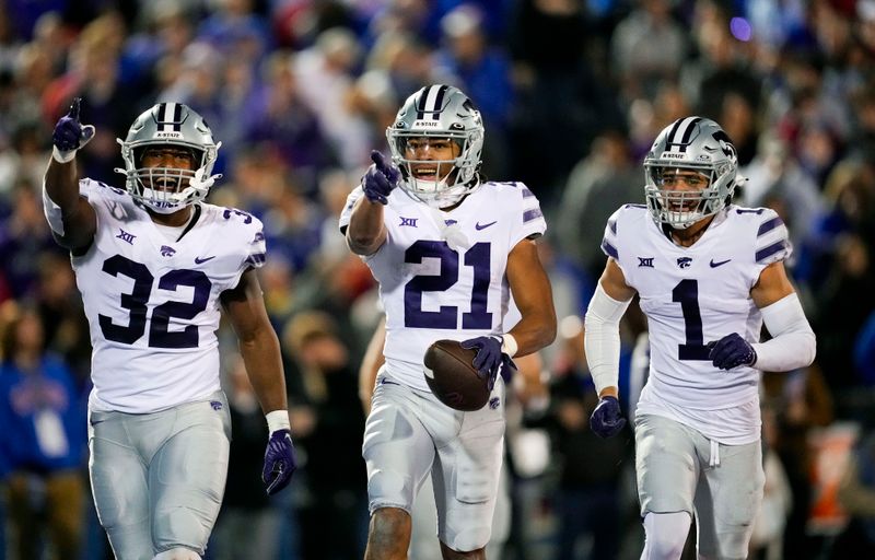 Nov 18, 2023; Lawrence, Kansas, USA; Kansas State Wildcats safety Marques Sigle (21) celebrates with linebacker Desmond Purnell (32) and cornerback Keenan Garber (1) after an interception during the second half against the Kansas Jayhawks at David Booth Kansas Memorial Stadium. Mandatory Credit: Jay Biggerstaff-USA TODAY Sports