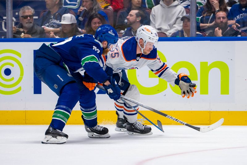 May 8, 2024; Vancouver, British Columbia, CAN; Vancouver Canucks defenseman Ian Cole (82) checks Edmonton Oilers forward Dylan Holloway (55) during the second period in game one of the second round of the 2024 Stanley Cup Playoffs at Rogers Arena. Mandatory Credit: Bob Frid-USA TODAY Sports