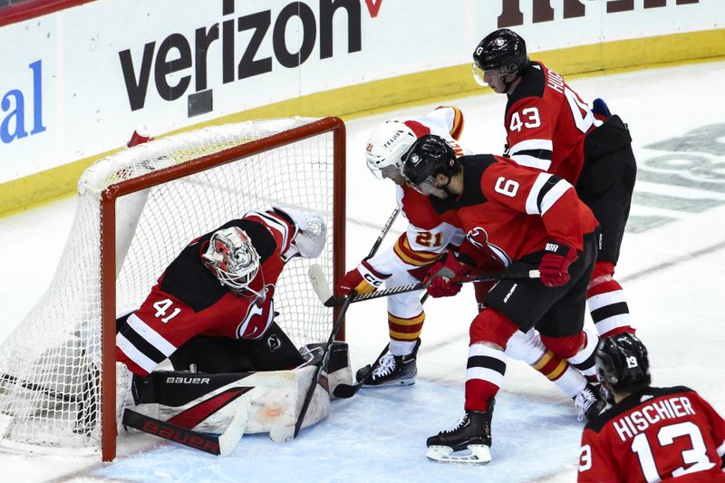 Feb 8, 2024; Newark, New Jersey, USA; Calgary Flames center Kevin Rooney (21) scores a goal against New Jersey Devils goaltender Vitek Vanecek (41) during the third period at Prudential Center. Mandatory Credit: John Jones-USA TODAY Sports