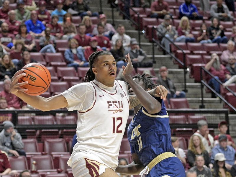 Jan 18, 2025; Tallahassee, Florida, USA;  Florida State Seminoles forward Malique Ewin (12) drives the ball past Georgia Tech Yellowjackets forward Baye Ndongo (11) during the first half at Donald L. Tucker Center. Mandatory Credit: Robert Myers-Imagn Images