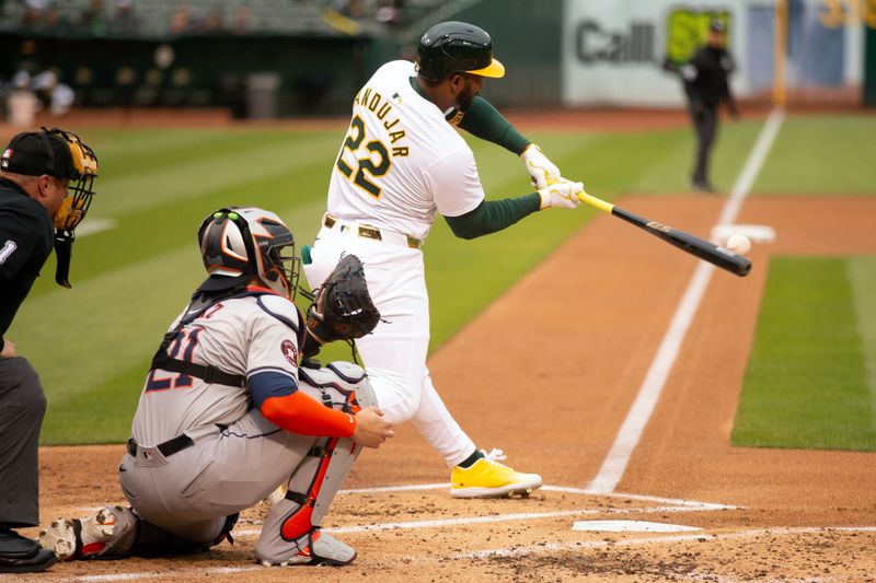 May 24, 2024; Oakland, California, USA; Oakland Athletics left fielder Miguel Andujar (22) connects for an RBI single against the Houston Astros during the first inning at Oakland-Alameda County Coliseum. Mandatory Credit: D. Ross Cameron-USA TODAY Sports