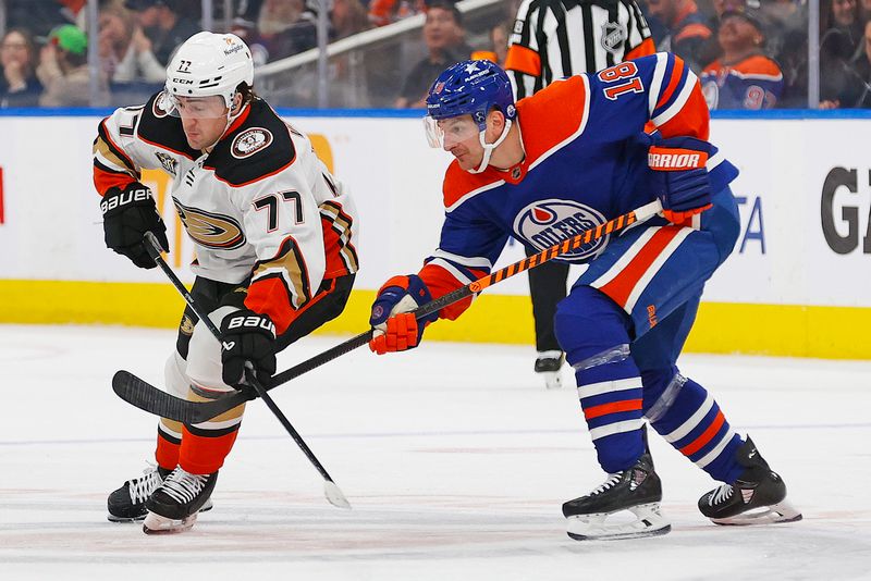 Nov 26, 2023; Edmonton, Alberta, CAN; Anaheim Ducks forward Frank Vatrano (77) and Edmonton Oilers forward Zach Hyman (18) look for a loose puck during the second period at Rogers Place. Mandatory Credit: Perry Nelson-USA TODAY Sports