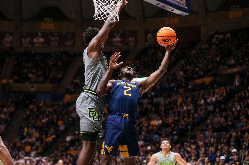 Feb 17, 2024; Morgantown, West Virginia, USA; West Virginia Mountaineers guard Kobe Johnson (2) shoots against Baylor Bears center Yves Missi (21) during the second half at WVU Coliseum. Mandatory Credit: Ben Queen-USA TODAY Sports