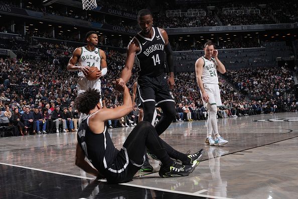 BROOKLYN, NY - DECEMBER 27: Harry Giles III #14 helps up Jalen Wilson #22 of the Brooklyn Nets during the game against the Milwaukee Bucks on December 27, 2023 at Barclays Center in Brooklyn, New York. NOTE TO USER: User expressly acknowledges and agrees that, by downloading and or using this Photograph, user is consenting to the terms and conditions of the Getty Images License Agreement. Mandatory Copyright Notice: Copyright 2023 NBAE (Photo by Jesse D. Garrabrant/NBAE via Getty Images)