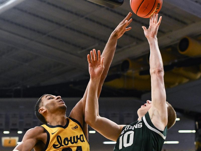 Feb 25, 2023; Iowa City, Iowa, USA; Iowa Hawkeyes forward Kris Murray (24) defends the shot of Michigan State Spartans forward Joey Hauser (10) during the first half at Carver-Hawkeye Arena. Mandatory Credit: Jeffrey Becker-USA TODAY Sports