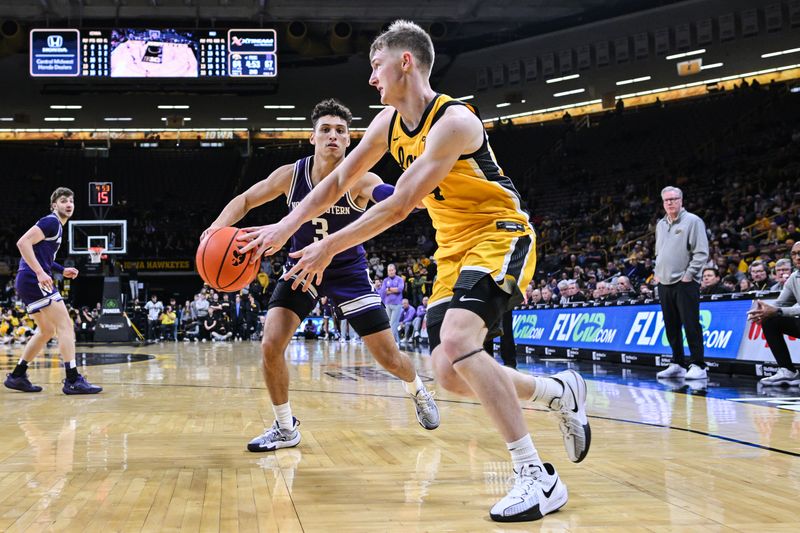 Dec 3, 2024; Iowa City, Iowa, USA; Iowa Hawkeyes guard Josh Dix (4) passes the ball as Northwestern Wildcats guard Ty Berry (3) defends during the second half at Carver-Hawkeye Arena. Mandatory Credit: Jeffrey Becker-Imagn Images