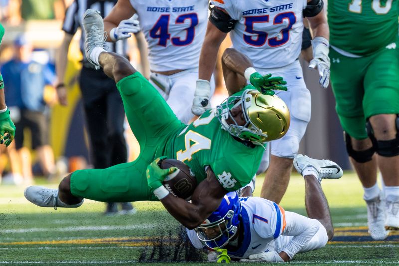 Oct 4, 2025; South Bend, Indiana, USA; Notre Dame Fighting Irish running back Jadarian Price (24) gets upended by Boise State Broncos defensive back A'Marion McCoy (7) during the second half at Notre Dame Stadium. Mandatory Credit: Michael Caterina-Imagn Images