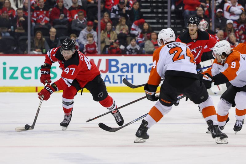 Jan 18, 2025; Newark, New Jersey, USA; New Jersey Devils center Paul Cotter (47) plays the puck while being defended by Philadelphia Flyers defenseman Nick Seeler (24) during the second period at Prudential Center. Mandatory Credit: Ed Mulholland-Imagn Images