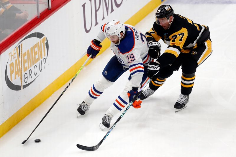 Mar 10, 2024; Pittsburgh, Pennsylvania, USA;  Edmonton Oilers center Leon Draisaitl (29) shields the puck against Pittsburgh Penguins center Jeff Carter (77) during the third period at PPG Paints Arena. The Oilers won 4-0. Mandatory Credit: Charles LeClaire-USA TODAY Sports