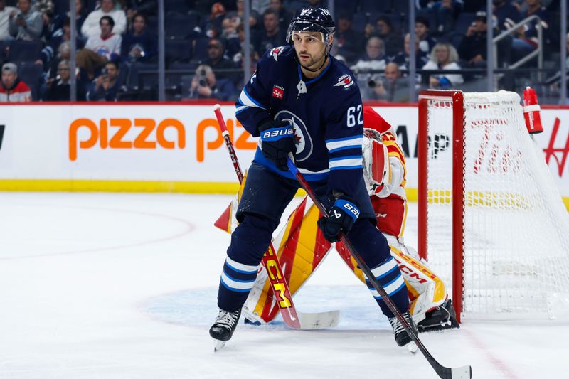 Oct 2, 2024; Winnipeg, Manitoba, CAN;  Winnipeg Jets forward Nino Niederreiter (62) screens Calgary Flames goalie Dustin Wolf (32) during the second period at Canada Life Centre. Mandatory Credit: Terrence Lee-Imagn Images