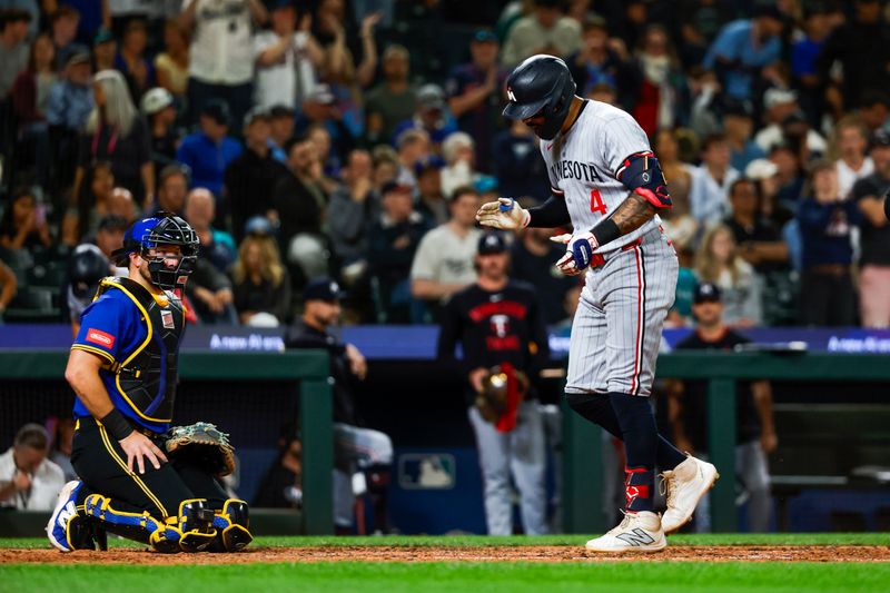 May 30, 2025; Seattle, Washington, USA; Minnesota Twins shortstop Carlos Correa (4) celebrates after hitting a two-run home run against the Seattle Mariners during the tenth inning at T-Mobile Park. Seattle Mariners catcher Cal Raleigh (29) kneels at left. Mandatory Credit: Joe Nicholson-Imagn Images