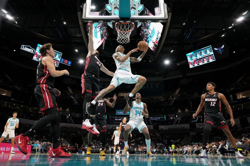 CHARLOTTE, NORTH CAROLINA - OCTOBER 08: Tre Mann #23 of the Charlotte Hornets goes to the basket against Kevin Love #42 of the Miami Heat during the first half of the preseason game at Spectrum Center on October 08, 2024 in Charlotte, North Carolina. NOTE TO USER: User expressly acknowledges and agrees that, by downloading and or using this photograph, User is consenting to the terms and conditions of the Getty Images License Agreement. (Photo by Grant Halverson/Getty Images)