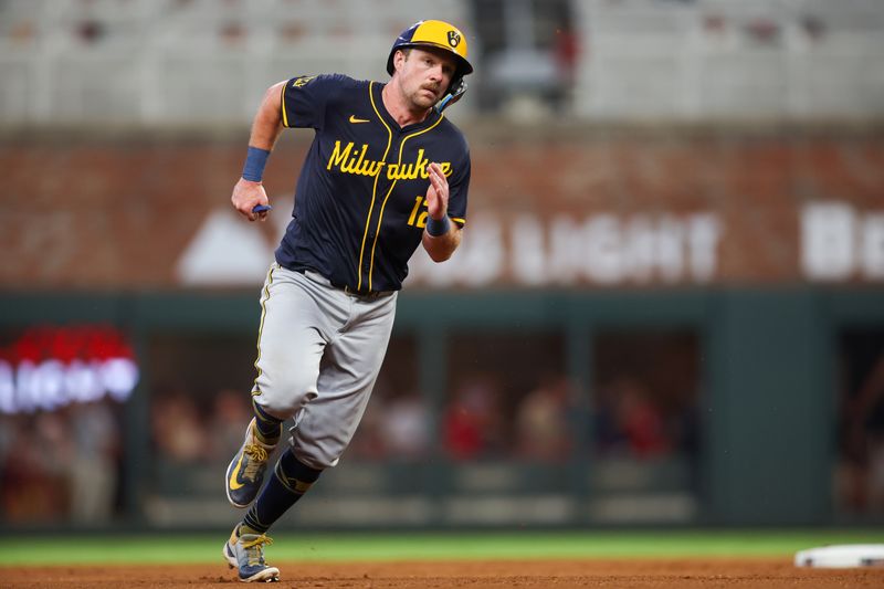 Aug 7, 2024; Atlanta, Georgia, USA; Milwaukee Brewers first baseman Rhys Hoskins (12) runs to third against the Atlanta Braves in the fifth inning at Truist Park. Mandatory Credit: Brett Davis-USA TODAY Sports
