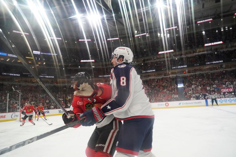 Dec 1, 2024; Chicago, Illinois, USA; Columbus Blue Jackets defenseman Zach Werenski (8) and Chicago Blackhawks left wing Nick Foligno (17) check each other during the second period at United Center. Mandatory Credit: David Banks-Imagn Images