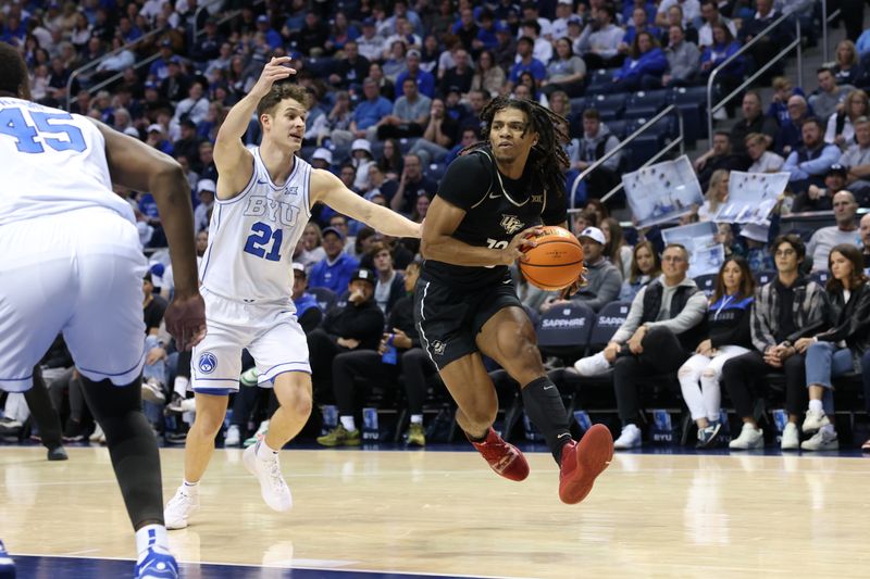 Feb 13, 2024; Provo, Utah, USA; Central Florida Knights guard DeMarr Langford Jr. (12) goes to the basket against Brigham Young Cougars guard Trevin Knell (21) during the first half at Marriott Center. Mandatory Credit: Rob Gray-USA TODAY Sports