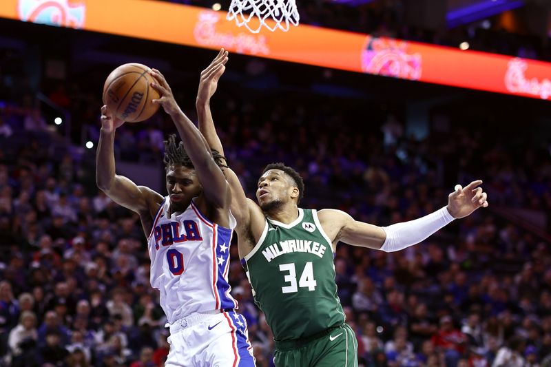 PHILADELPHIA, PENNSYLVANIA - FEBRUARY 25: Tyrese Maxey #0 of the Philadelphia 76ers reaches for a rebound past Giannis Antetokounmpo #34 of the Milwaukee Bucks during the third quarterat the Wells Fargo Center on February 25, 2024 in Philadelphia, Pennsylvania. (Photo by Tim Nwachukwu/Getty Images)