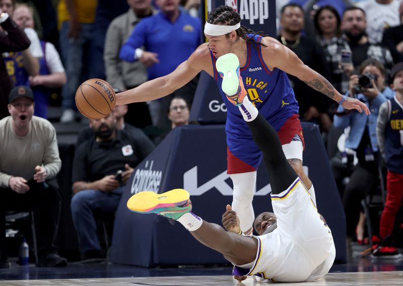 DENVER, COLORADO - APRIL 20: LeBron James #23 of the Los Angeles Lakers falls to the court against Aaron Gordon #50 of the Denver Nuggets in the fourth quarter during game one of the Western Conference First Round Playoffs at Ball Arena on April 20, 2024 in Denver, Colorado.  NOTE TO USER: User expressly acknowledges and agrees that, by downloading and or using this photograph, User is consenting to the terms and conditions of the Getty Images License Agreement. (Photo by Matthew Stockman/Getty Images)