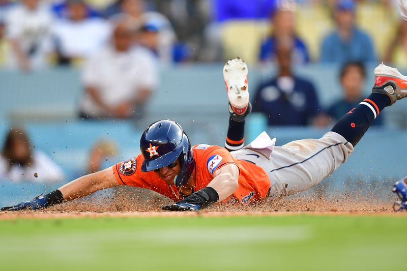 Jun 25, 2023; Los Angeles, California, USA; Houston Astros second baseman Mauricio Dubon (14) scores a run against the Los Angeles Dodgers during the eleventh inning at Dodger Stadium. Mandatory Credit: Gary A. Vasquez-USA TODAY Sports