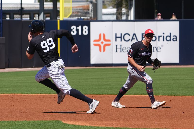 Mar 6, 2025; Tampa, Florida, USA; New York Yankees outfielder Aaron Judge (99) heads to third base after a hit by outfielder Cody Bellinger (35) as Minnesota Twins shortstop Brooks Lee (2) looks on during the first inning at George M. Steinbrenner Field. Mandatory Credit: Dave Nelson-Imagn Images