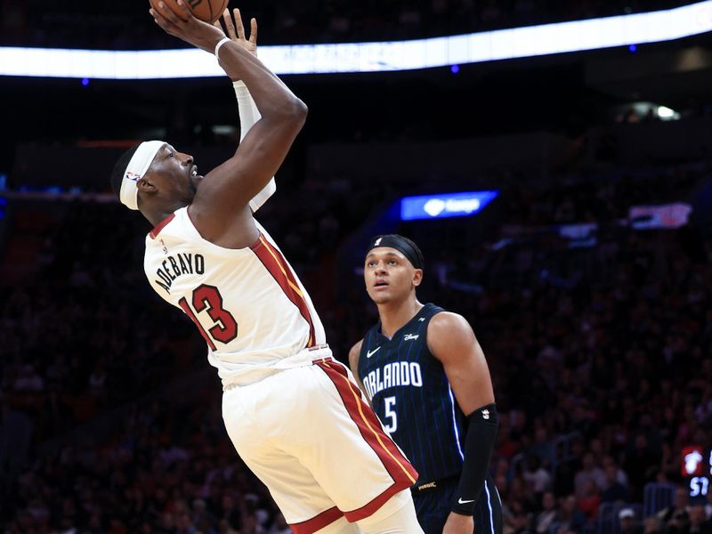 MIAMI, FLORIDA - OCTOBER 23: Bam Adebayo #13 of the Miami Heat shoots over Paolo Banchero #5 of the Orlando Magic during the second half at Kaseya Center on October 23, 2024 in Miami, Florida. NOTE TO USER: User expressly acknowledges and agrees that, by downloading and or using this photograph, User is consenting to the terms and conditions of the Getty Images License Agreement. (Photo by Carmen Mandato/Getty Images)