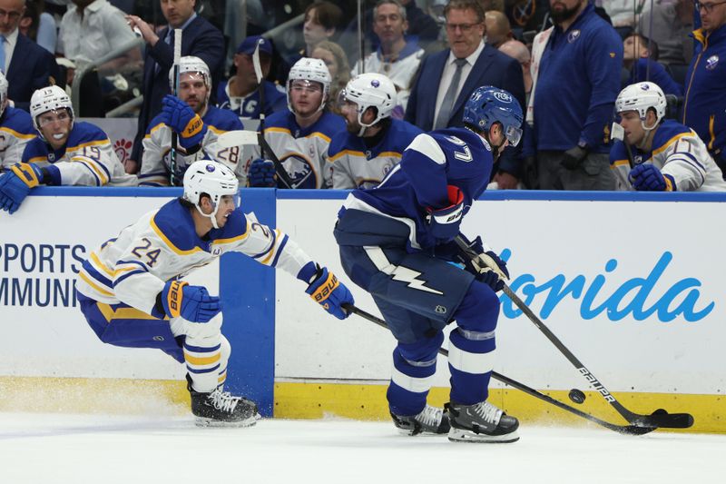 Feb 29, 2024; Tampa, Florida, USA;  Tampa Bay Lightning defenseman Victor Hedman (77) and Buffalo Sabres center Dylan Cozens (24) fight for the puck in the second period at Amalie Arena. Mandatory Credit: Nathan Ray Seebeck-USA TODAY Sports