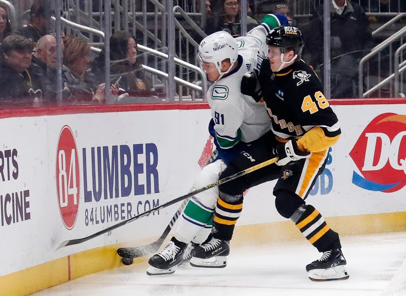 Jan 11, 2024; Pittsburgh, Pennsylvania, USA; Pittsburgh Penguins right wing Valtteri Puustinen (48) checks Vancouver Canucks defenseman Nikita Zadorov (91) during the first period at PPG Paints Arena. Mandatory Credit: Charles LeClaire-USA TODAY Sports