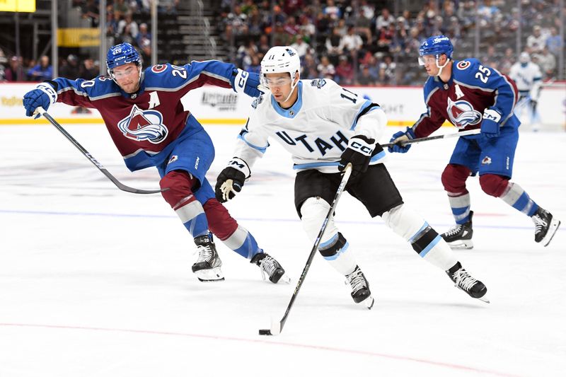 Sep 29, 2024; Denver, Colorado, USA; Utah Hockey Club forward Dylan Guenther (11) skates with the puck past Colorado Avalanche center Ross Colton (20) before assisting on a goal during the third period at Ball Arena. Mandatory Credit: Christopher Hanewinckel-Imagn Images