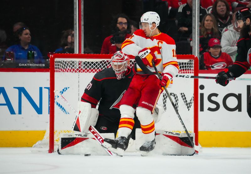 Mar 10, 2024; Raleigh, North Carolina, USA;  Carolina Hurricanes goaltender Frederik Andersen (31) makes a save against Calgary Flames center Mikael Backlund (11) during the third period at PNC Arena. Mandatory Credit: James Guillory-USA TODAY Sports