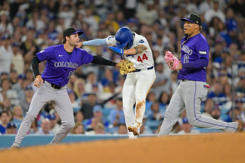 Sep 10, 2025; Los Angeles, California, USA; Los Angeles Dodgers center fielder Andy Pages (44) is tagged out by Colorado Rockies third baseman Kyle Karros (12) as shortstop Orlando Arcia (11) looks on during a rundown play in the fourth inning at Dodger Stadium. Mandatory Credit: Jayne Kamin-Oncea-Imagn Images