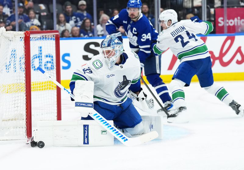 Jan 10, 2026; Toronto, Ontario, CAN;  Vancouver Canucks goaltender Kevin Lankinen (32) stops the puck against the Toronto Maple Leafs during the third period at Scotiabank Arena. Mandatory Credit: Nick Turchiaro-Imagn Images