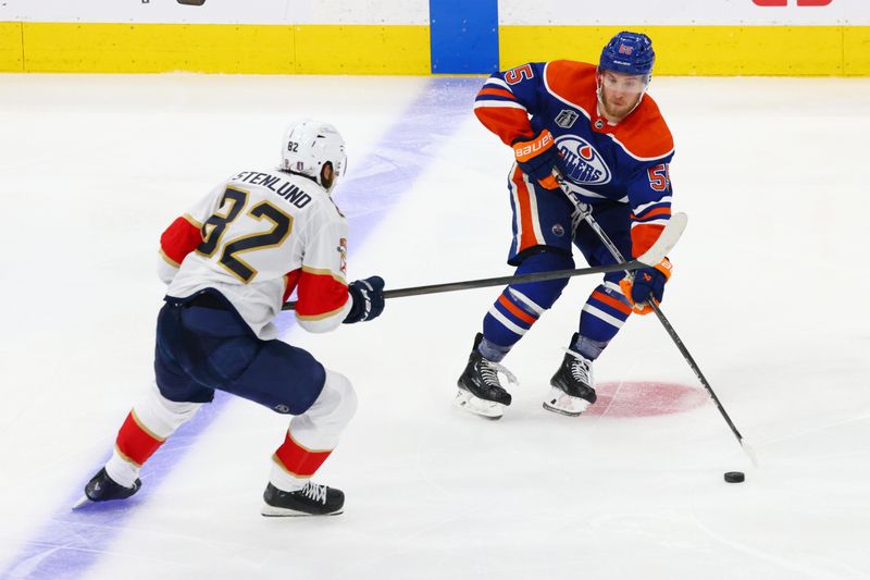 Jun 15, 2024; Edmonton, Alberta, CAN; Edmonton Oilers left wing Dylan Holloway (55) skates with the puck defended by Florida Panthers center Kevin Stenlund (82) in the third period in game four of the 2024 Stanley Cup Final at Rogers Place. Mandatory Credit: Sergei Belski-USA TODAY Sports