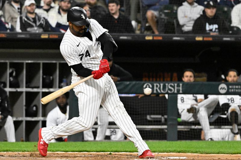 May 11, 2024; Chicago, Illinois, USA;  Chicago White Sox designated hitter Eloy Jiménez (74) hits a double against the Cleveland Guardians during the eighth inning at Guaranteed Rate Field. Mandatory Credit: Matt Marton-USA TODAY Sports