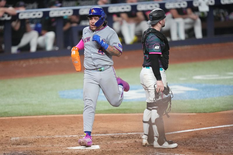 Sep 27, 2025; Miami, Florida, USA;  New York Mets catcher Francisco Alvarez (4) scores a run in the ninth inning as Miami Marlins catcher Liam Hicks (34) looks on at loanDepot Park. Mandatory Credit: Jim Rassol-Imagn Images