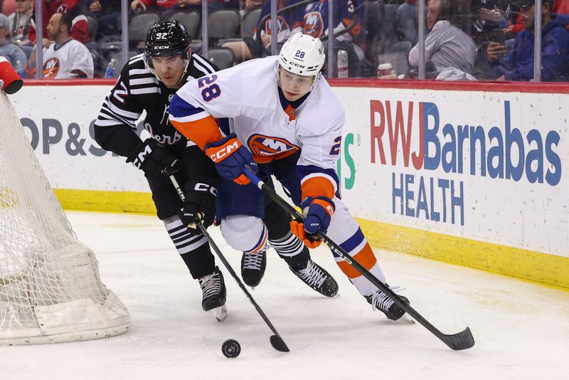 Apr 15, 2024; Newark, New Jersey, USA; New York Islanders defenseman Alexander Romanov (28) and New Jersey Devils left wing Tomas Nosek (92) battle for the puck during the second period at Prudential Center. Mandatory Credit: Ed Mulholland-USA TODAY Sports