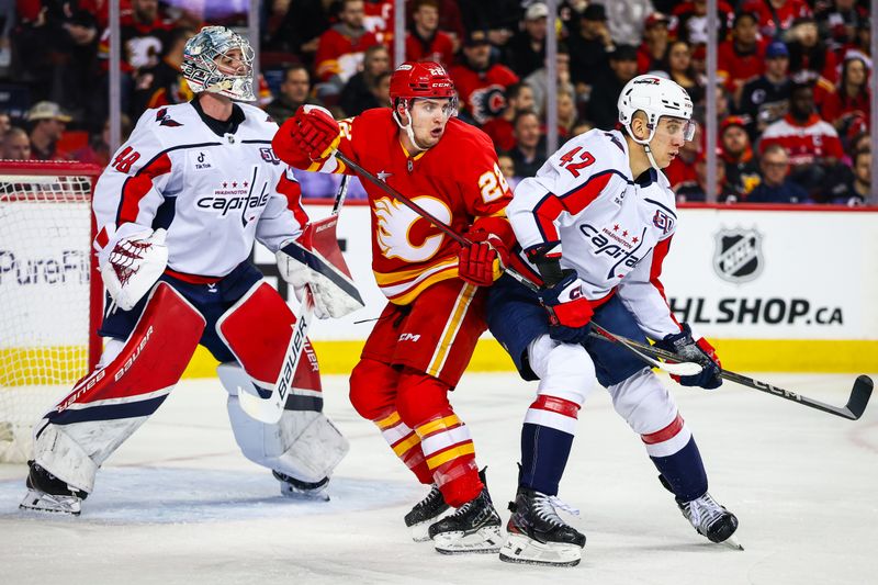 Jan 28, 2025; Calgary, Alberta, CAN; Calgary Flames left wing Jakob Pelletier (22) and Washington Capitals defenseman Martin Fehervary (42) fights for position in front of Washington Capitals goaltender Logan Thompson (48) during the second period at Scotiabank Saddledome. Mandatory Credit: Sergei Belski-Imagn Images