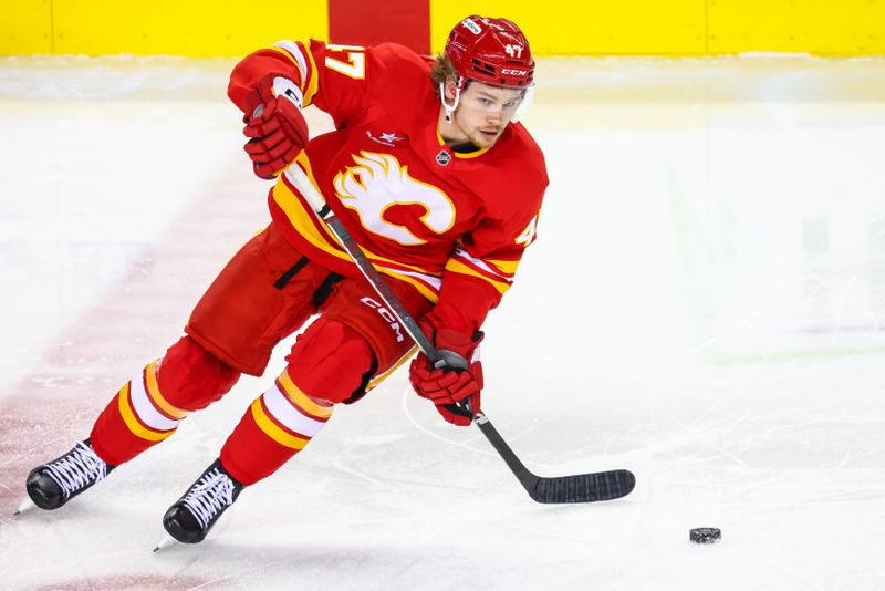 Nov 3, 2024; Calgary, Alberta, CAN; Calgary Flames center Connor Zary (47) controls the puck during the warmup period against the Edmonton Oilers at Scotiabank Saddledome. Mandatory Credit: Sergei Belski-Imagn Images