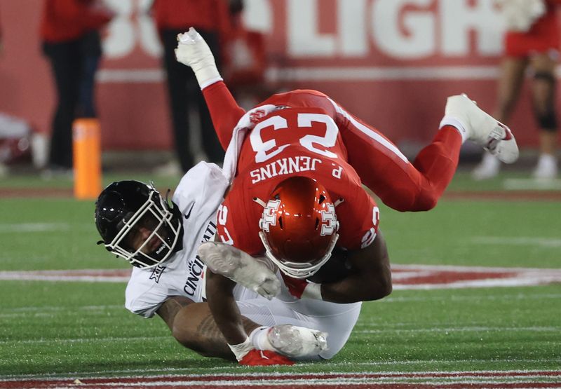 Nov 11, 2023; Houston, Texas, USA; Houston Cougars running back Parker Jenkins (23) is tackled by Cincinnati Bearcats defensive end Justin Wodtly (95)  in the first half at TDECU Stadium. Mandatory Credit: Thomas Shea-USA TODAY Sports