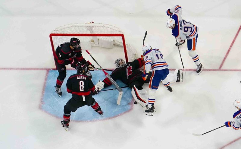 Nov 22, 2023; Raleigh, North Carolina, USA; Carolina Hurricanes goaltender Pyotr Kochetkov (52) stops the scoring attempt by Edmonton Oilers left wing Zach Hyman (18) during the third period at PNC Arena. Mandatory Credit: James Guillory-USA TODAY Sports